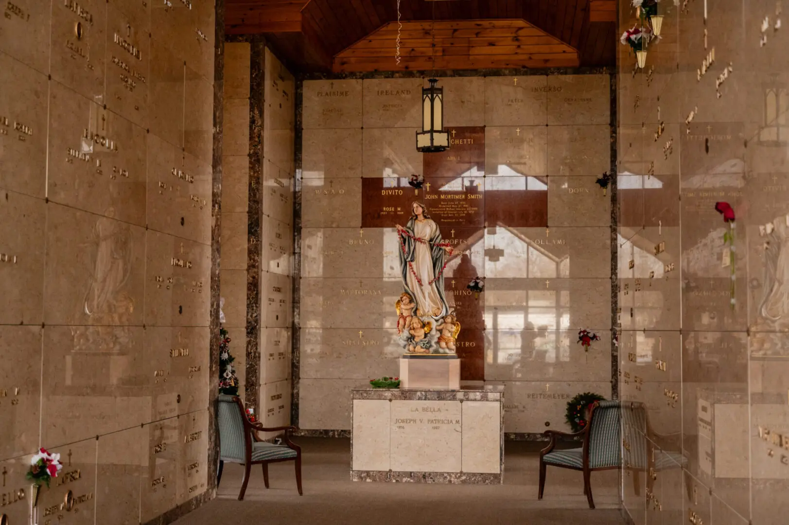 Mausoleum interior with statue and chairs.